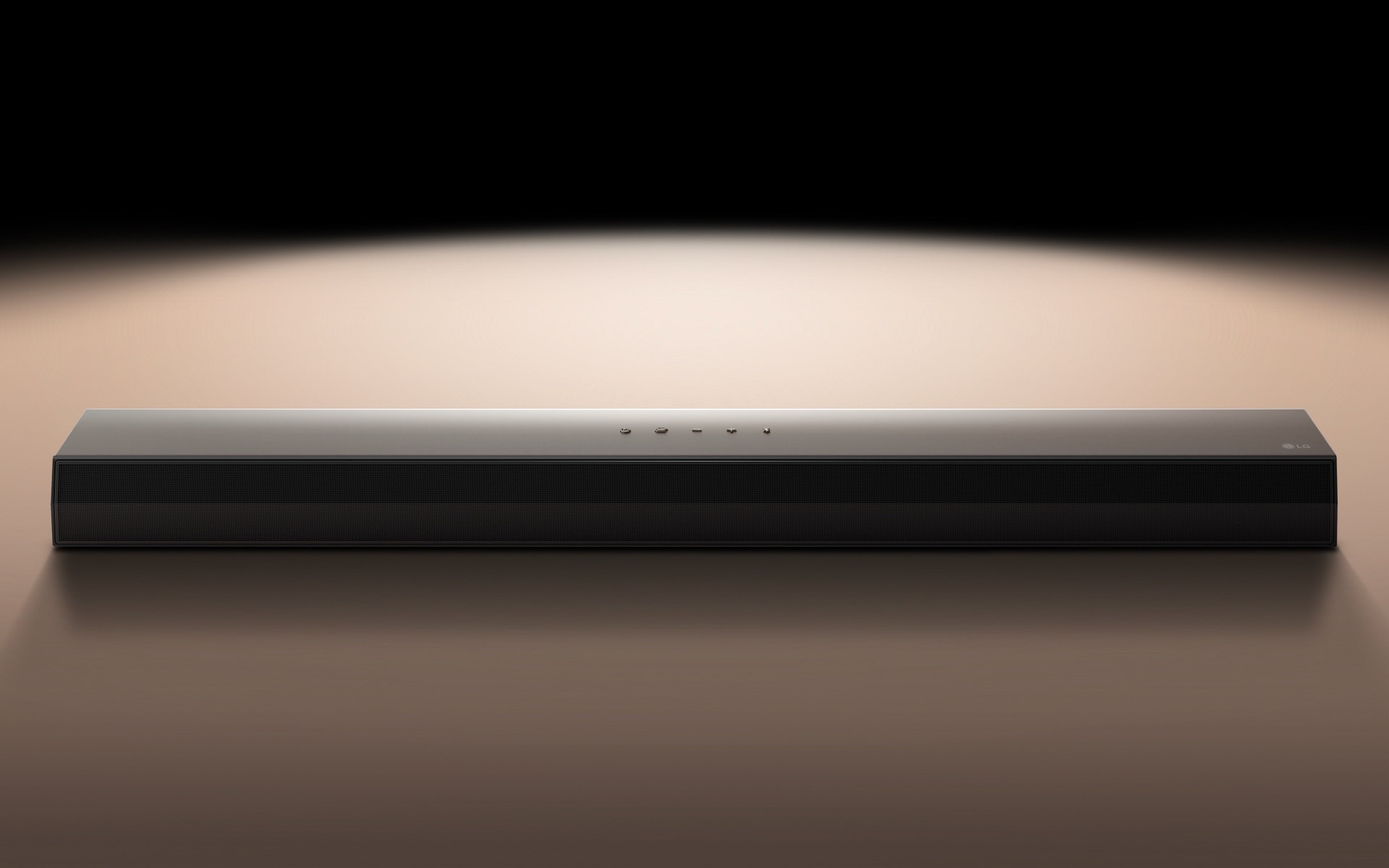 LG Soundbar against a black backdrop highlighted by a spotlight