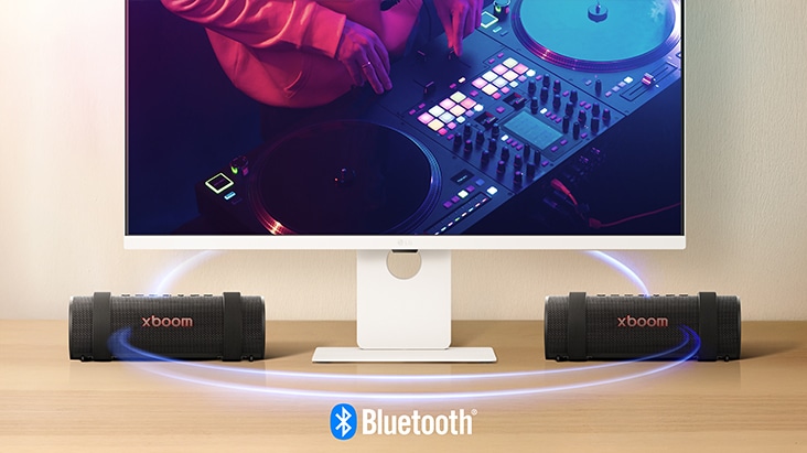 LG Smart Monitor is showing a DJing scene and two units of xboom Grab are placed on both side of the monitor.