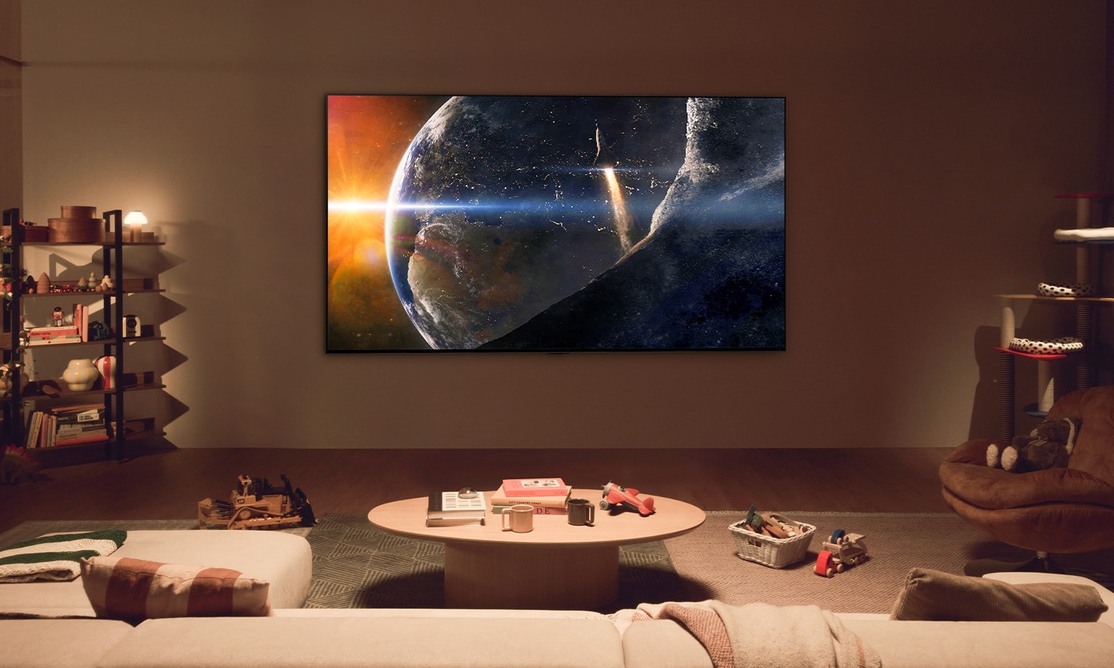 A family sits on the floor of a low-lit living room, looking up at an LG TV mounted on the wall showing the Earth from space.